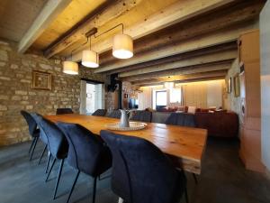 a dining room with a wooden table and chairs at Grain d'orge et cornouiller in Bulson