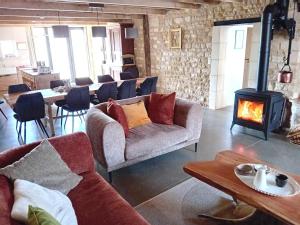 a living room with two couches and a wood stove at Grain d'orge et cornouiller in Bulson