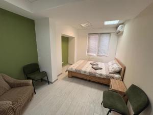 ein Schlafzimmer mit einem Bett, zwei Stühlen und einem Fenster in der Unterkunft Ethno Hostel in Chişinău