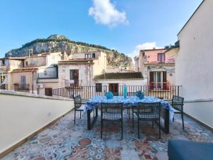 a patio with a table and chairs on a balcony at Luxury House in Cefalù