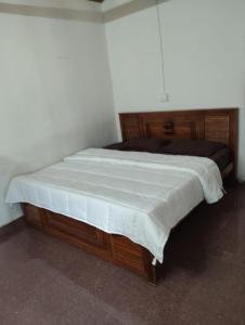 a bedroom with a large bed with a wooden frame at Armaan's mud mart in Kodaikānāl +11 photos