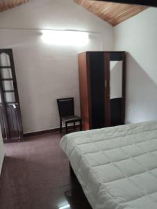 a bedroom with a bed and a chair in it at Armaan's mud mart in Kodaikānāl