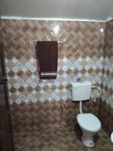 a bathroom with a toilet and a towel at Armaan's mud mart in Kodaikānāl