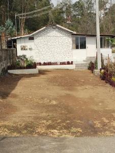 a house with a dirt yard in front of it at Armaan's mud mart in Kodaikānāl