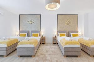 a bedroom with three beds with yellow pillows at SONNENglück - Großes Apartment für 8 im Zentrum mit flexiblen Betten, Balkon & Parkplatz in Altusried