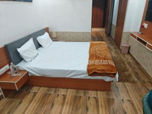 a bedroom with a bed with a blanket on it at The R B Tower in Unnāo