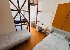 a room with two beds and a desk and a ladder at Lisboa Hostel in Lisbon