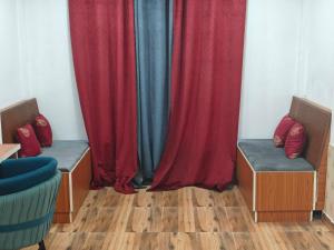 a room with red and blue curtains and benches at The R B Tower in Unnāo