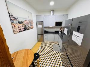 a small kitchen with a table and a refrigerator at Lisboa Hostel in Lisbon