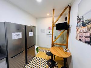 a small room with a table and a refrigerator at Lisboa Hostel in Lisbon