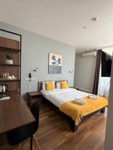a bedroom with a bed and a table and a desk at Hotel Vista in Tbilisi City