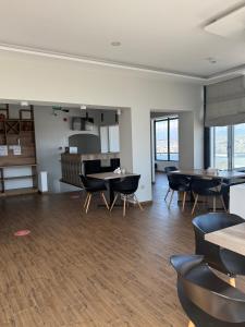 a room with tables and chairs and a kitchen at Hotel Vista in Tbilisi City +37 photos