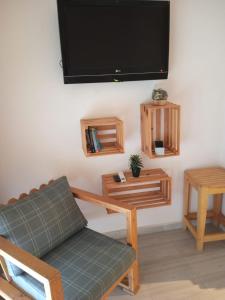 a living room with a couch and a flat screen tv at Jardin de bougainvillier in Sfax