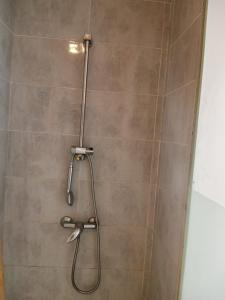 a shower with a shower head in a bathroom at Jardin de bougainvillier in Sfax