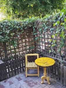 a wooden table and a wooden chair and a table and a bench at Jardin de bougainvillier in Sfax +4 photos