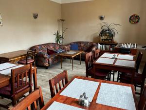 a living room with a couch and tables and chairs at Penzion Ostravanka in Hranice