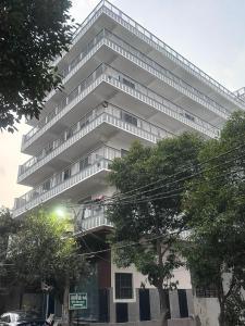 a tall white building with balconies on it at Sukoon Stays in Noida