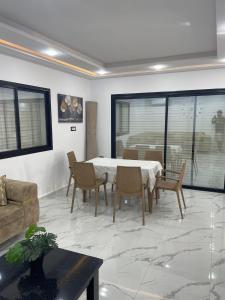 a living room with a table and chairs and a couch at Villa Assef in Midoun +4 photos