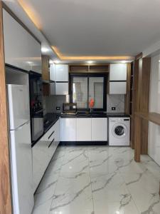 a kitchen with white cabinets and a washer and dryer at Villa Assef in Midoun