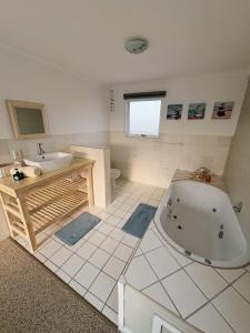 a bathroom with a tub and a sink at Linga Longa in Britannia Bay +49 photos