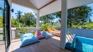 a balcony with a swimming pool and pillows at FarmSaijai Kohphangan in Hinkong