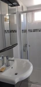 a bathroom with a white sink and a shower at La maison de poupées in Bourseul +4 photos