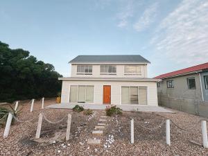a white house with a fence in front of it at Linga Longa in Britannia Bay