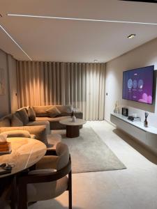 a living room with a couch and a flat screen tv at Luxe Appartement Haut Standing Nador Lagoon Rif in Nador