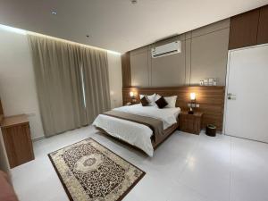 a bedroom with a large bed and a rug at شقق الورود بارك in Al Mikhlaf +18 photos