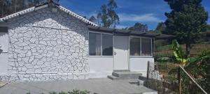 a small white house with a stone facade at Armaan's mud mart in Kodaikānāl