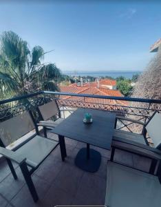 a table and chairs on a balcony with the ocean at Klapidis apartments in Kriopigi