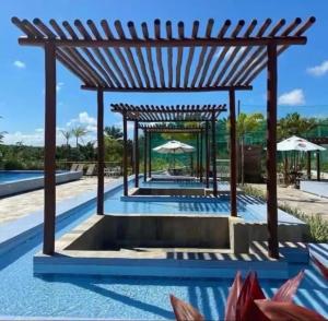 a swimming pool with a pergola on top of it at Apartamento completo, moderno e bem localizado in Parnamirim