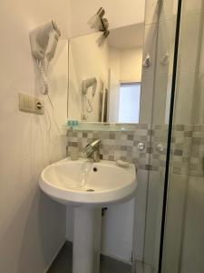 a bathroom with a sink and a shower at Hotel Vista in Tbilisi City