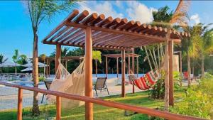 a group of hammocks in a pavilion near a pool at Apartamento completo, moderno e bem localizado in Parnamirim