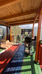 a house with a deck with a piano on it at Northland Bungalows in Çayırdüzü