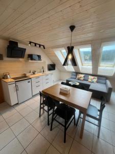 a kitchen and dining room with a table and a couch at Horský penzion a bistro Čepice in Pernink
