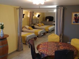 a hotel room with three beds and a table at Le Logis du Livier in Saint-Georges-sur-Layon