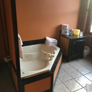 a bath tub in a bathroom with a sink at Main Street Bed & Breakfast in Hannibal