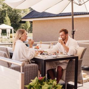 a man and woman sitting at a table drinking coffee at Beauty Concept SPA in Lübeck