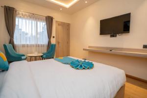 a hotel room with a bed and a flat screen tv at Hotel Crown Plaza in Kathmandu