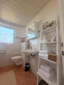 a white bathroom with a sink and a toilet at Cozy Home in Schramberg