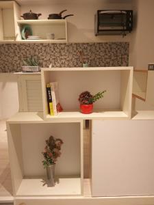 a white shelf with two plants in a room at Charmant studio à Sfax in Sfax +5 photos