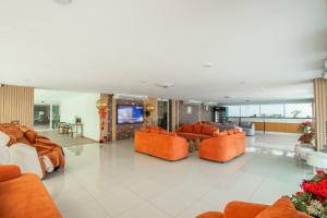 a living room with orange chairs and a couch at Dwija Hotel & Suite in Pattaya South
