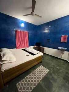 a bedroom with a bed and a sink and a ceiling fan at Gravity Groups Blue Lagoon Villa in Kuilapayam