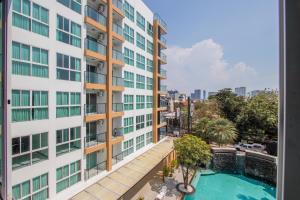 an apartment with a swimming pool and a building at Dwija Hotel & Suite in Pattaya South