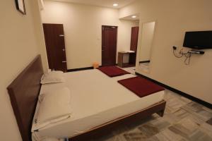 a bedroom with a large bed in a room at Hotel Rayas in Kumbakonam