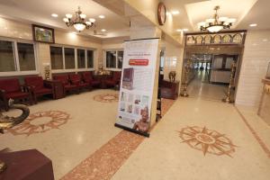 a lobby with chairs and a sign on the floor at Hotel Rayas in Kumbakonam