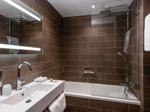 a bathroom with a tub and a sink and a bath tub at Pullman Paris Tour Eiffel in Paris +135 photos