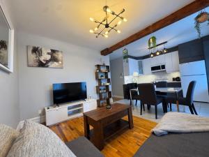 a living room with a television and a dining room at La Pause Montréal in Montreal