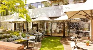 an outdoor restaurant with tables and chairs and umbrellas at DoubleTree by Hilton London - Hyde Park in London +73 photos